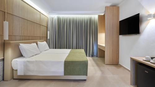 a hotel room with a bed and a television at Eleni Holiday Resort in Paphos City