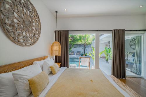 a bedroom with a bed and a sliding glass door at Villa Lemone by Bali Villa Solutions in Seminyak