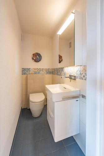 ヴィンタートゥールにあるChez Sabine - la vie en couleursの白い洗面台とトイレのあるバスルーム