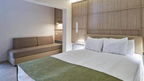 a bedroom with a large bed and a couch at Eleni Holiday Resort in Paphos City