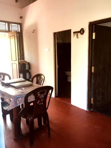 a dining room with a table and chairs and a bathroom at Lakshmi Villa in Aluthgama