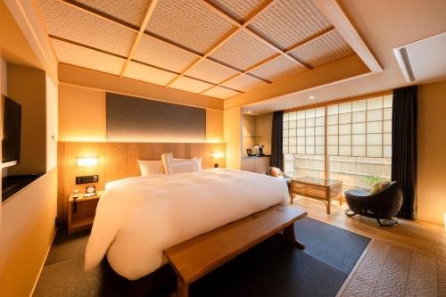 a bedroom with a large bed and a large window at Homm Stay Nagi Arashiyama Kyoto By Banyan Group in Kyoto