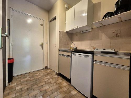 une cuisine avec des armoires blanches, un évier et un lave-vaisselle dans l'établissement Résidence Le Saint Charles A - Studio idéalement situé à 50 m des Thermes Chevalley ! MAE-7704, à Aix-les-Bains