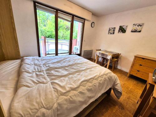 une chambre avec un grand lit et une fenêtre dans l'établissement Résidence Le Saint Charles A - Studio idéalement situé à 50 m des Thermes Chevalley ! MAE-7704, à Aix-les-Bains