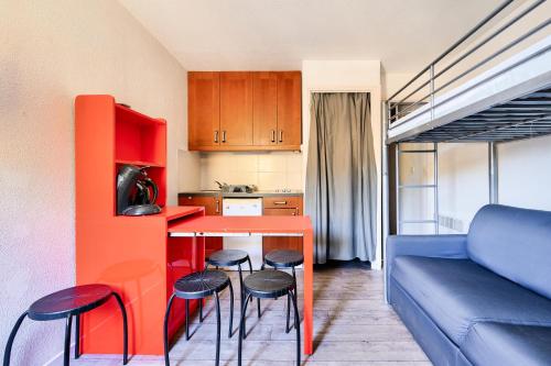- une petite cuisine avec une table et des tabourets dans la chambre dans l'établissement Résidence Le Tourmalet - maeva Home - Studio 3 personnes - Confort MAE-5281, à La Mongie