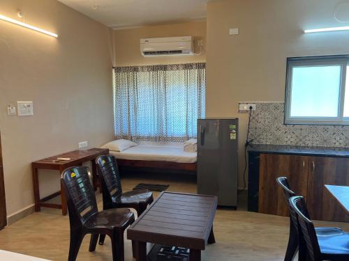 a small room with a bed and a table and chairs at OmBodhi Retreat in Kumta
