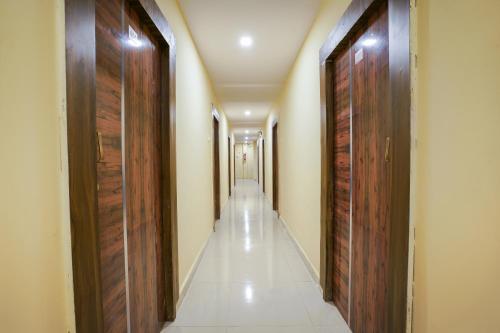 a hallway with wooden doors and a long corridor at Hotel O R Square Stay Near LB Nagar Metro in Hyderabad