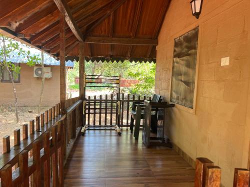 a porch of a house with a wooden floor at OmBodhi Retreat in Kumta