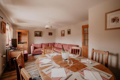 un salon avec une table et un canapé dans l'établissement Gîte du Fronholz - Maison alsacienne avec jardin et service traiteur, à Epfig