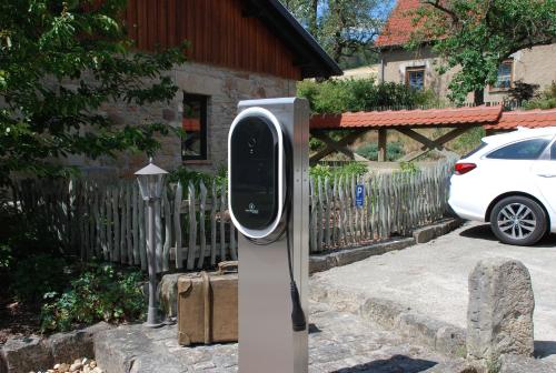 a parking meter in front of a house with a car at Landkulturhof Glücksbringer in Rudolstadt