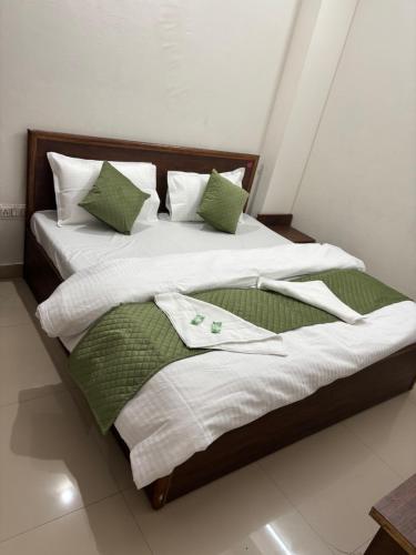 a bed with green and white blankets and pillows at Hotel moon river in Rāiwāla