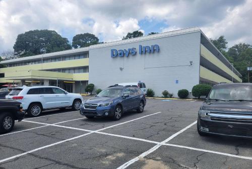 a car dealership with cars parked in a parking lot at Days Inn by Wyndham Alexandria South in Alexandria
