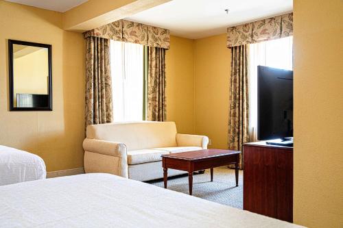 a hotel room with a bed and a chair and a television at Hampton Inn Charleston-Historic District in Charleston