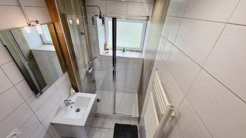 a small bathroom with a shower and a sink at KerElo Le Ptit St Roch, maisonnette cosy, mer 5km, Ploudalmezeau in Ploudalmézeau