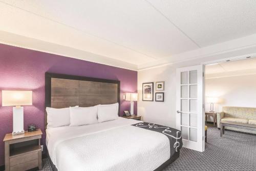 a hotel room with a large bed and purple walls at La Quinta by Wyndham Austin Airport in Austin