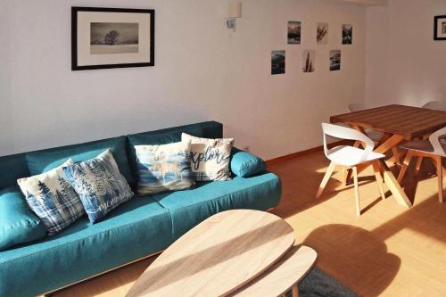 un salon avec un canapé bleu et une table dans l'établissement Résidence Parc Des Airelles - APPARTEMENT PARC DES AIRELLES 111 MAE-0224, aux Orres