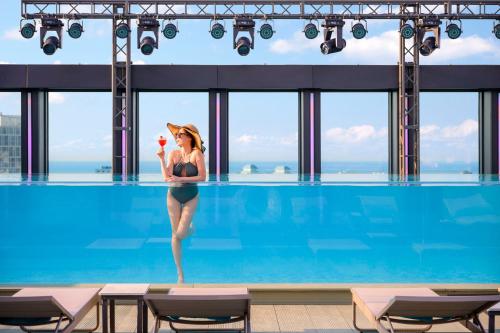 a woman standing in a swimming pool with an ice cream at Jeju Bolton Hotel in Jeju