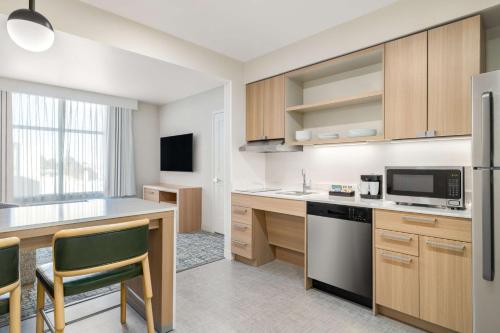 an apartment kitchen with a counter and a refrigerator at Homewood Suites By Hilton Thornton Denver in Thornton