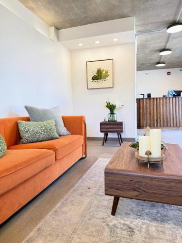 an orange couch in a living room with a coffee table at The Alice Hotel in Tucson