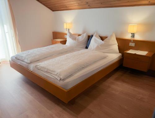 a bedroom with a large bed with white sheets and pillows at Active B&B Prairerhof in Schenna