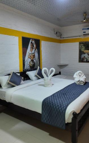 a bedroom with a large bed with a wedding picture on the wall at Le Royal Resort- By the Beach in Tarangambādi