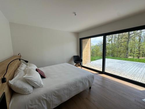 a bedroom with a bed and a large window at Domaine de Haslach, The Originals Collection, Résidence de Tourisme in Munster
