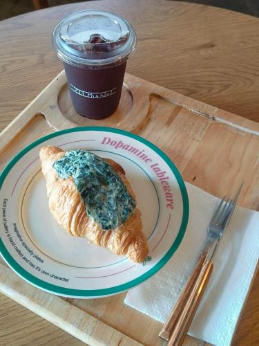 a plate with a piece of bread and a cup of coffee at Family Room by 233Poshtel in Lampang