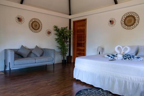 a bedroom with a white bed and a couch at U Story Resort in Siquijor
