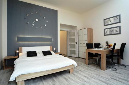 a bedroom with a bed and a desk and a table at Navratilova Apartments in Prague