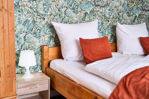 a bedroom with a bed with a tropical wallpaper at Hotel Maximo in Pinneberg