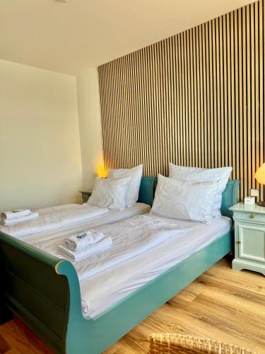 a bedroom with a large bed with a wooden headboard at Gästehaus Weserblick am Weser-Sandstrand in Berne