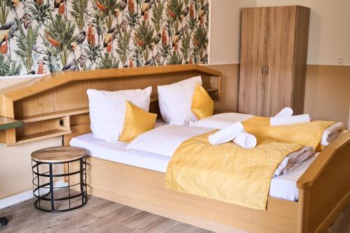 a bedroom with a large wooden bed with towels on it at Hotel Maximo in Pinneberg