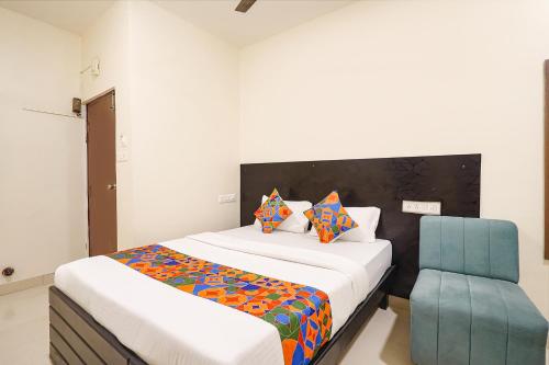 a bedroom with a bed and a blue chair at FabHotel Maark Inn - Bannerghatta Rd in Bengaluru