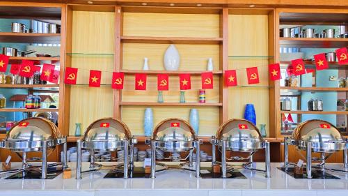 a restaurant with a table with chairs and red flags at FLC Grand Hotel Quy Nhon in Quy Nhon