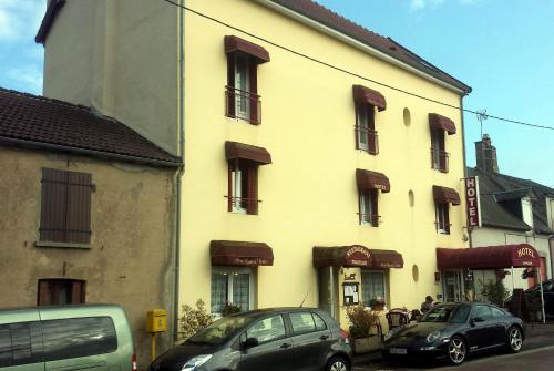 duży budynek z samochodami zaparkowanymi przed nim w obiekcie Aux Quatre Vents w mieście Saulieu