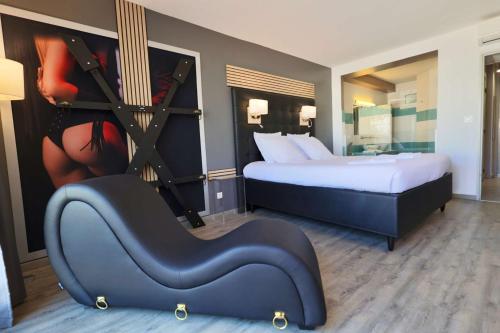 une chambre d'hôtel avec un lit et une chaise dans l'établissement LOVE ROOM Jardin d'Eden JE108 - Suite Junior Premium, au Cap d'Agde