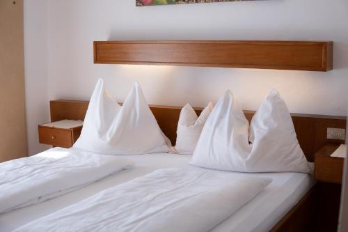 a bed with white pillows on top of it at Active B&B Prairerhof in Schenna