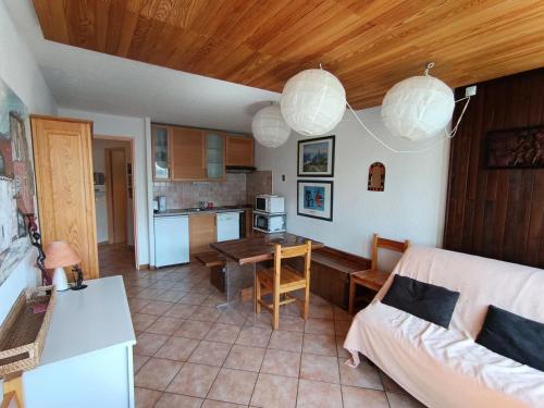 un salon avec une table et une cuisine dans l'établissement Résidence Loubatiere - Appartement 2 pièces + cabine pour 4/6 personnes MAE-8924, à Montgenèvre