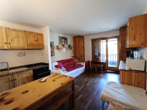 une cuisine et un salon avec une table et un canapé dans l'établissement Résidence Le Sommet - Appartement avec terrasse et jardinet - Belle vue - Parking couvert MAE-9094, à Montgenèvre