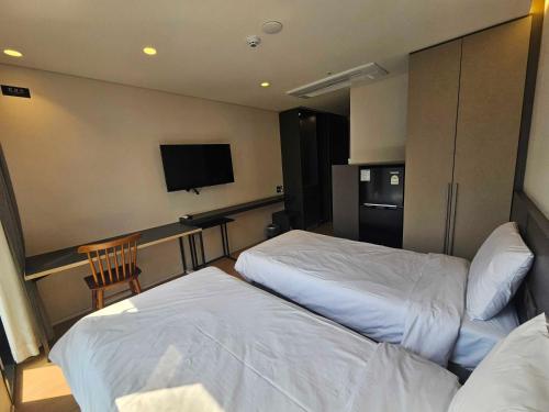 a hotel room with two beds and a television at Celib Yeoui in Seoul