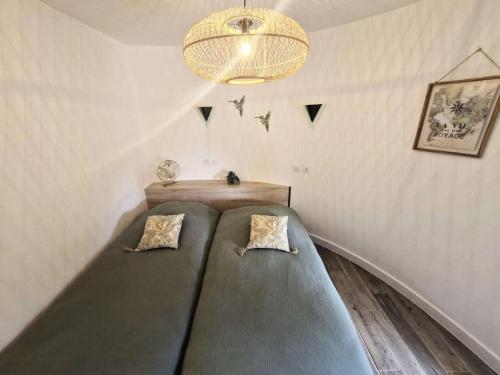 Cette chambre comprend 2 lits et un lustre. dans l'établissement Résidence Ile Des Pecheurs - VILLA 3 PIECES 6 couchages LE BARCARES MAE-6674, à Port-Leucate