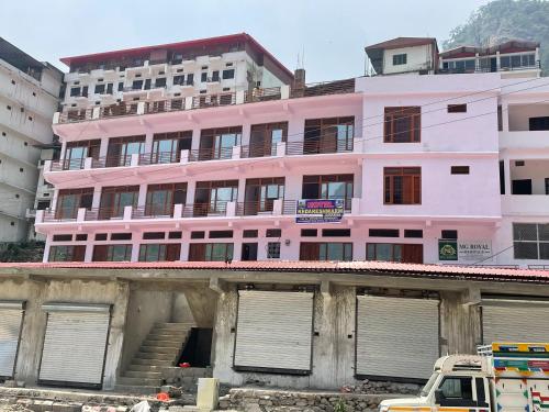 un edificio rosa delante de un edificio en Hotel Kedareswram, en Sonprayag