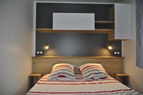 une chambre avec un lit avec deux oreillers dessus dans l'établissement Panorama Vue Mer, à Quiberon