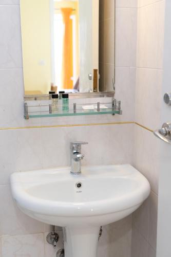 a bathroom with a white sink and a mirror at Remezzo Apartments in Sami
