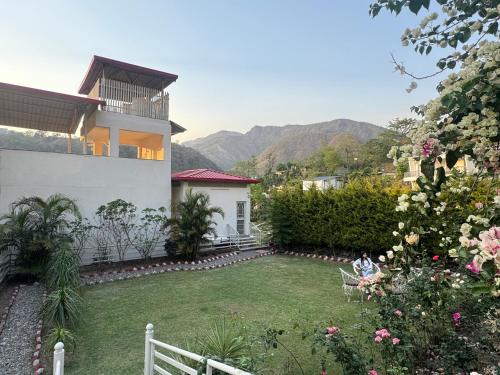 Eine Frau, die auf einer Bank im Garten eines Hauses sitzt. in der Unterkunft Bella Casa, 3BHK LUX Villa Private Gardens & Mountain Views in Dehradun