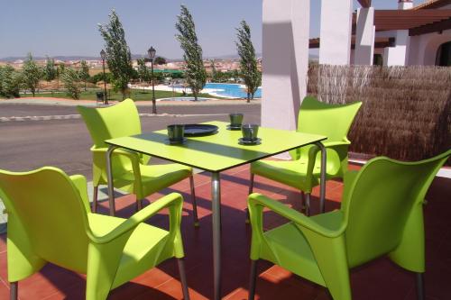 a green table and chairs on a patio at Camping la Sierrecilla in Humilladero