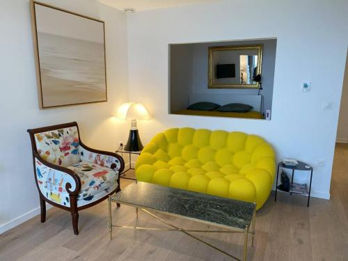 - un salon avec un canapé jaune et une chaise dans l'établissement Appartement rénové avec jardin, WIFI, parking à 750m de la plage à Perros-Guirec - FR-1-368-452, à Perros-Guirec