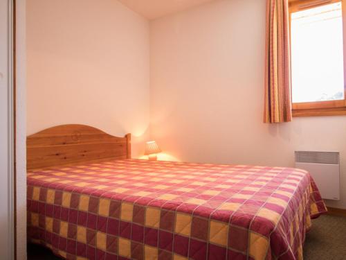 une chambre avec un lit avec une couverture à carreaux dans l'établissement Appartement confortable 6 pers, proche navettes, à Aussois - FR-1-508B-2, à Aussois