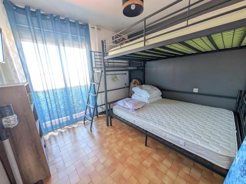 une chambre avec un lit superposé et une échelle dans l'établissement Appartement T3 Moderne 5/6 Pers. avec Piscine et Parking - FR-1-797-63, à Port-la-Nouvelle