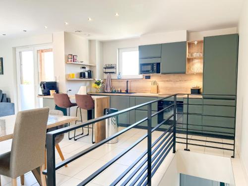 - une cuisine et une salle à manger avec des armoires et des chaises bleues dans l'établissement Charmante maison à Évian avec terrasse et parking - FR-1-498-113, à Évian-les-Bains